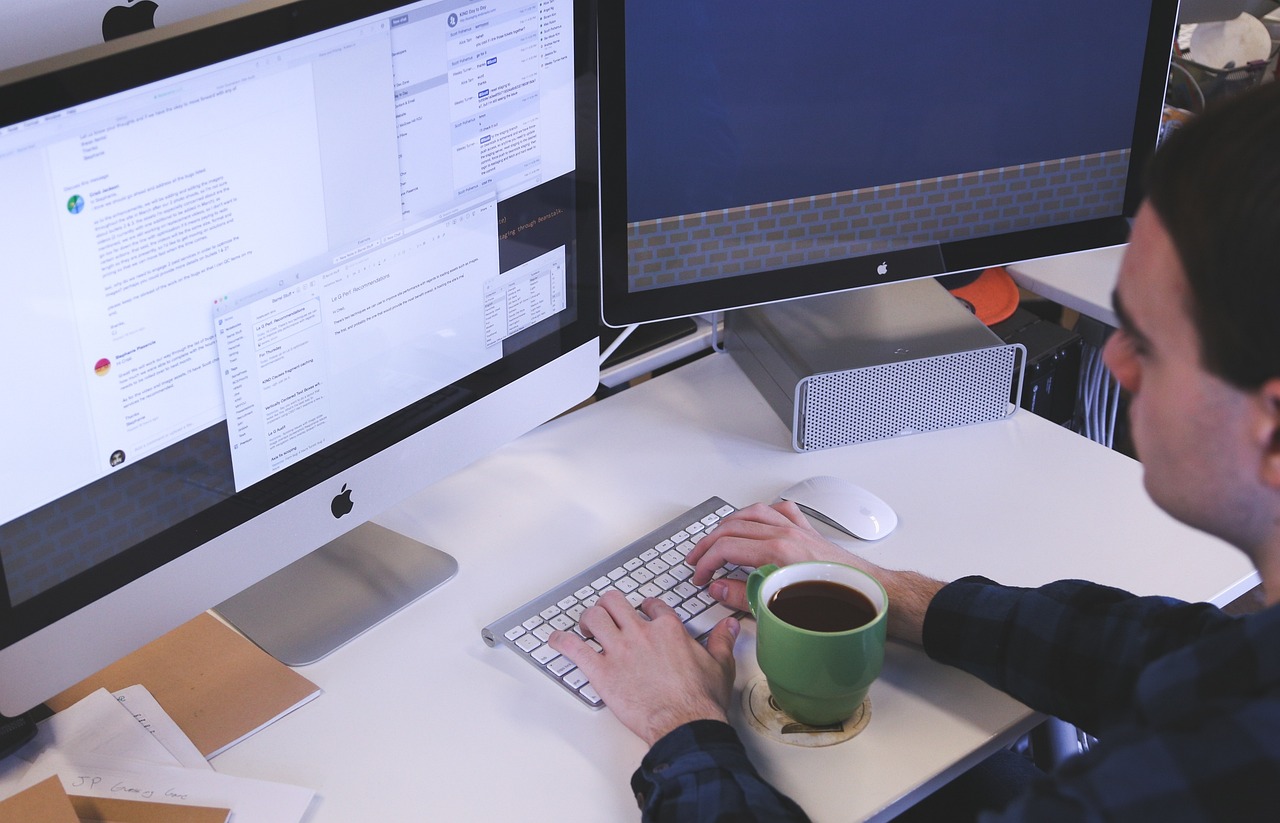 website testing by a man with a desktop and a coffee mug on table